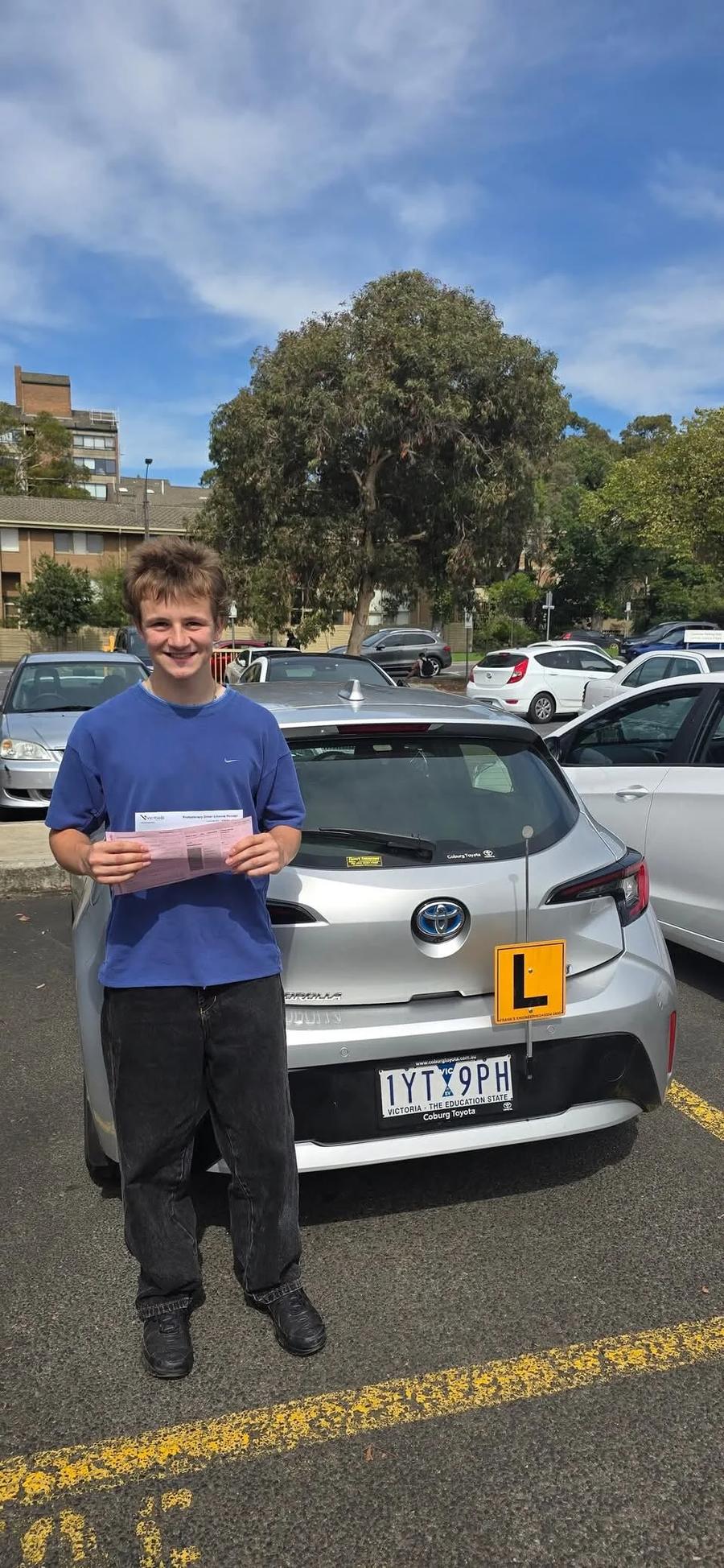 Happy learner holds VicRoads pass certificate after first-time pass — Freshers Driving School