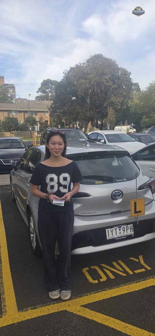 Student holds pink VicRoads pass slip — Freshers Driving School Melbourne