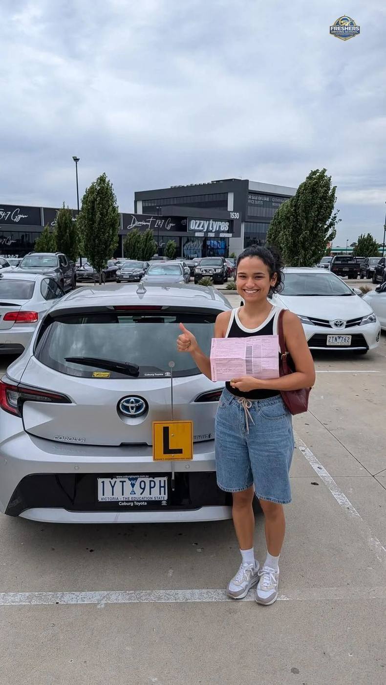 Happy student holds VicRoads pass certificate — Freshers Driving School Carlton