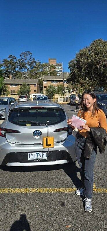 VicRoads accredited driving instructor Melbourne standing next to dual-control car in Carlton