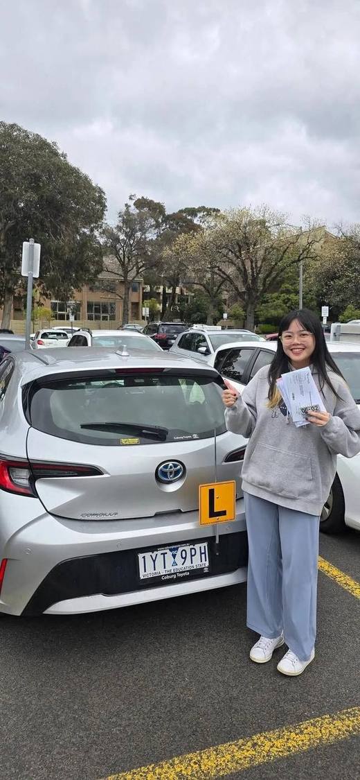 Student celebrating passing VicRoads drive test in Carlton Melbourne with Freshers Driving School